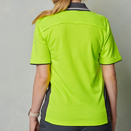  A rear view of a woman wearing a neon yellow polo shirt with gray accents and a reflective strip on the collar.