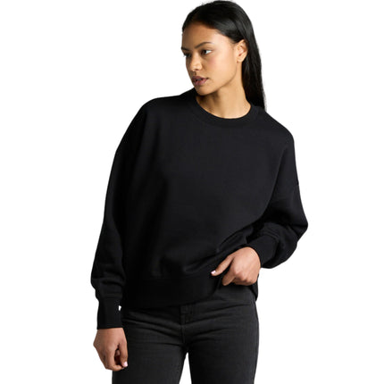 A model wearing a black AS Colour Women's Heavy Crew sweatshirt.