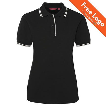 The JB's Wear Ladies' Contrast Polo by JB's Wear is a black, short-sleeved polo with white trim on the collar and sleeves. An orange banner states "Free Logo | 1 Front Digital Logo." Displayed on a plain white background.