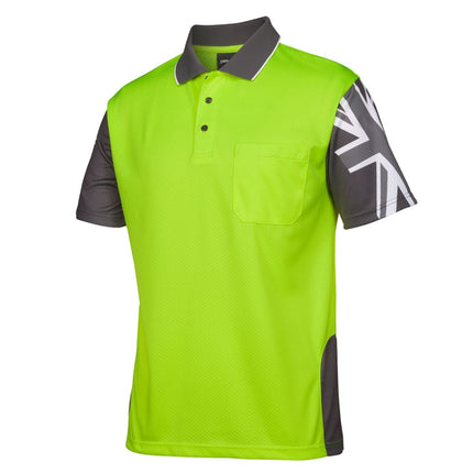 A close-up of a neon yellow and dark gray short-sleeve polo shirt. It has a high collar with white piping and features a Union Jack print on the left sleeve and a Southern Cross star on the right.