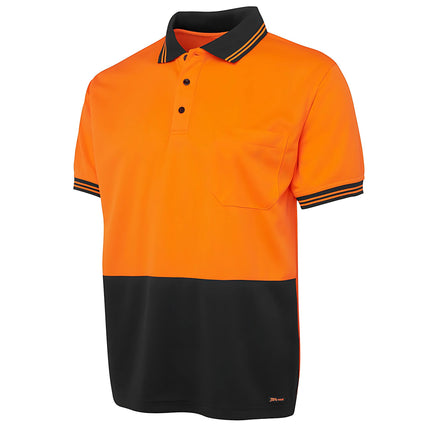 A close-up of a two-tone polo shirt. The top is bright orange, and the bottom is black. It has a high collar and sleeve cuffs with black stripes and a single chest pocket.
