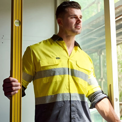 A person wears a neon yellow and dark gray long-sleeve work shirt. The shirt has gray reflective stripes and two button-down chest pockets