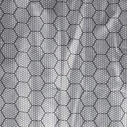 A close-up of a shiny, white reflective fabric. The pattern is a fine honeycomb design in black.