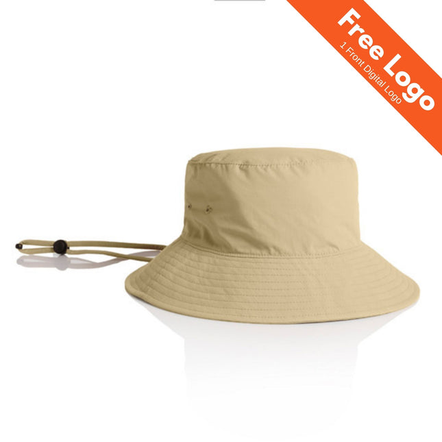 The AS Colour Nylon Wide Burn Bucket Hat in beige is made from recycled nylon, features UPF 50+, a chin strap, and adjustable toggle. Shown on white background with an orange “Free Logo” banner and “1 Front Digital Logo” text. Brand: AS Colour.