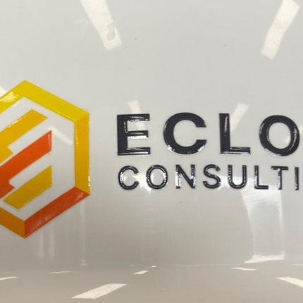 White hard hat with Eclon Consulting logo on a blurred background