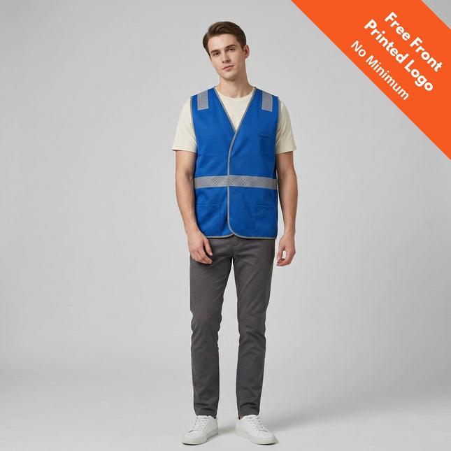 A man faces forward wearing the My Promo Shop Custom Coloured Safety Vest with reflective stripes over a light shirt and gray pants. An orange banner reads, "FREE Printed Logo - No Minimum Order." The background is plain light gray.