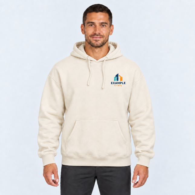 Model wearing AS Colour Heavy Hood 5146 in Ecru with an illustrative full-colour EXAMPLE CIVIL left-chest digital print, against a light cool-grey studio background.
