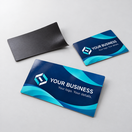 Custom glossy magnetic business cards with navy and teal printing and dark magnetic backing on a soft light grey background